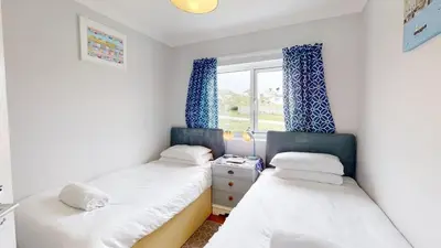 two beds in a small room with a window at D52 Boston, Riviere Towans in Hayle