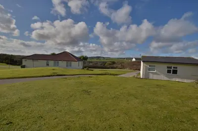 a house with a grassy yard in front of a house at D52 Boston, Riviere Towans in Hayle