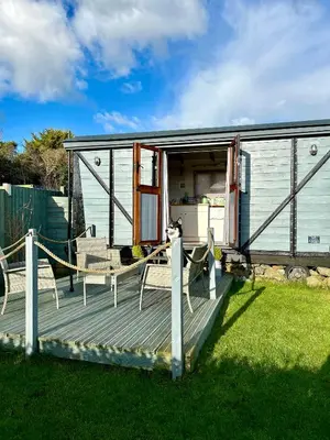 a house with a deck with chairs on it at Fry’s Carriage in Scorrier