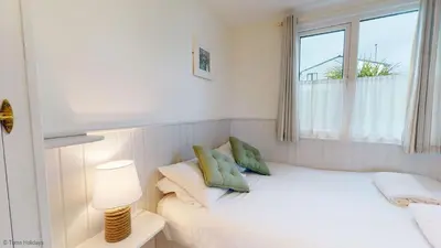 a small bedroom with a bed and a window at B07 Sea Esta B7, Riviere Towans in Hayle