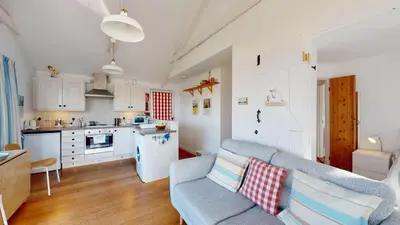 a living room with a couch and a kitchen at D22 Sandelite, Riviere Towans in Hayle