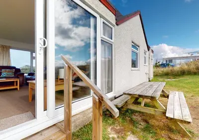 a wooden bench sitting outside of a house at B42 Shilly Chalet, Riviere Towans in Hayle