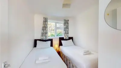 two beds in a small room with a window at C02 Lanta C2, Riviere Towans in Hayle