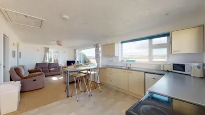 a kitchen and living room with a large window at C02 Lanta C2, Riviere Towans in Hayle