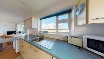 a kitchen with a sink and a large window at C02 Lanta C2, Riviere Towans in Hayle