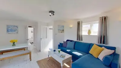a living room with a blue couch and a table at C17 Sandyridge, Riviere Towans in Hayle