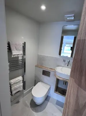 a bathroom with a toilet and a sink at Self contained double bedroom with ensuite, private entrance, free parking , 5 min walk to beach in St Ives