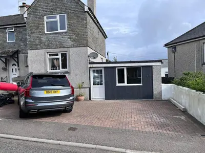 a car parked in a parking lot in front of a house at Self contained double bedroom with ensuite, private entrance, free parking , 5 min walk to beach in St Ives