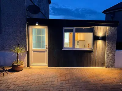 a house with a white door and a potted plant at Self contained double bedroom with ensuite, private entrance, free parking , 5 min walk to beach in St Ives