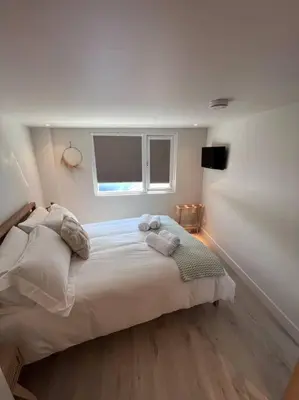 a bedroom with a large bed and a window at Self contained double bedroom with ensuite, private entrance, free parking , 5 min walk to beach in St Ives
