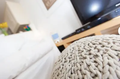 a close up of the arm of a couch with a television at 13 Carrack Widden with complimentary spa passes in St Ives