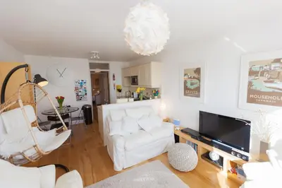 a living room with a white couch and a tv at 13 Carrack Widden with complimentary spa passes in St Ives