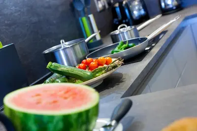 a counter with a bowl of vegetables and a bowl of watermelon at Bamaluz in Carbis Bay