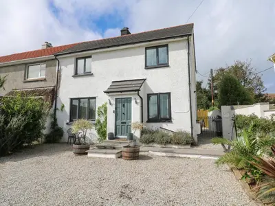 a white house with a gravel driveway at Cinders Loft in Redruth