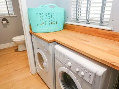 a laundry room with a washer and dryer at Cinders Loft in Redruth