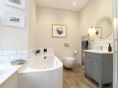 a bathroom with a tub and a toilet and a sink at Treveddoe Farmhouse in Bodmin