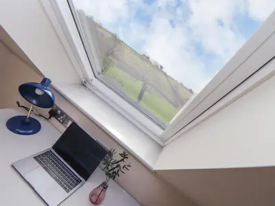 a laptop sitting on a desk next to a window at Treveddoe Farmhouse in Bodmin