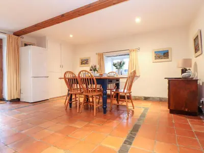 a kitchen with a table and chairs and a refrigerator at The Barley Crush in Bodmin