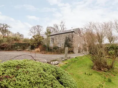 an old stone house in the middle of a yard at The Barley Crush in Bodmin