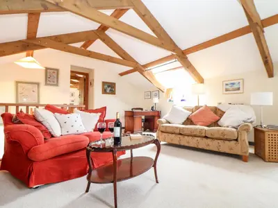 a living room with a red couch and a table at The Barley Crush in Bodmin