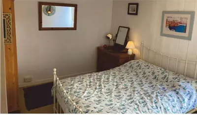 a bedroom with a bed and a mirror on the wall at The Sail Loft in Lostwithiel