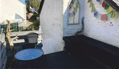 a patio with a table and chairs on a building at The Sail Loft in Lostwithiel