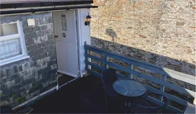 a blue bench next to a brick wall with a door at The Sail Loft in Lostwithiel