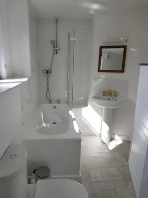 a white bathroom with a toilet and a sink at Hallagather Self Catering in Bude