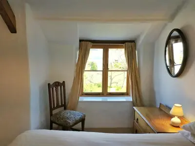 a bedroom with a desk and a chair and a window at Hallagather Self Catering in Bude