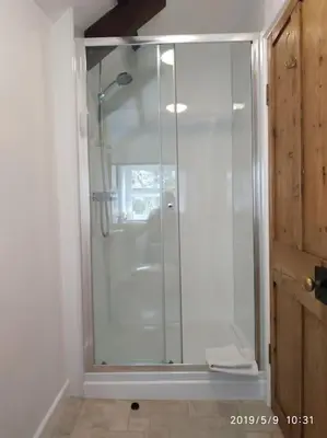 a shower with a glass door in a bathroom at Hallagather Self Catering in Bude