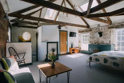 a bedroom with a bed and a table in a room at The Old Workshop in St Ives
