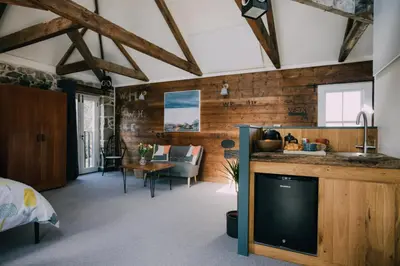 a bedroom with wooden walls and a tv in a room at The Old Workshop in St Ives