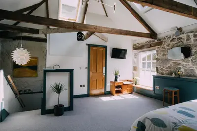 a bedroom with a bed and a wooden door at The Old Workshop in St Ives