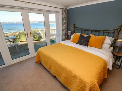 a bedroom with a bed with a yellow bedspread at Rosemount in Marazion