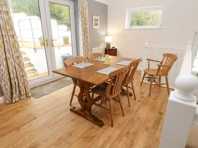 a dining room with a wooden table and chairs at Rosemount in Marazion