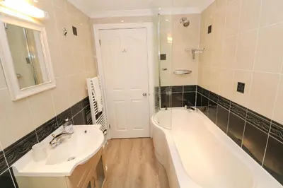 a bathroom with a tub and a sink and a bath tub at Rosemount in Marazion