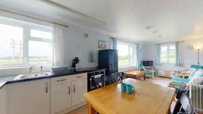 a kitchen with a table and a dining room at D57 Bramble, Riviere Towans in Hayle