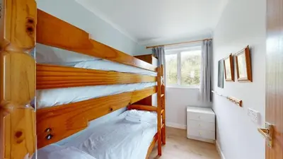 a bedroom with two bunk beds and a window at D57 Bramble, Riviere Towans in Hayle