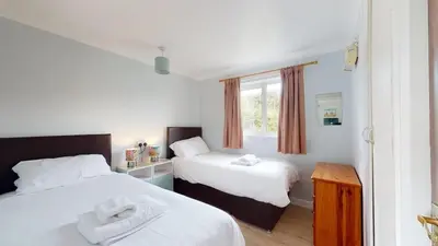 two beds in a small room with a window at D57 Bramble, Riviere Towans in Hayle
