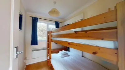 two bunk beds in a room with a window at D55 Wheal Lucy, Riviere Towans in Hayle