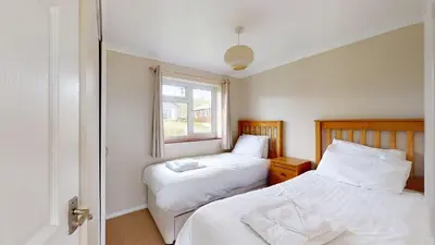 a bedroom with two beds and a window at D58 Penlee, Riviere Towans in Hayle