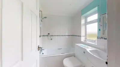 a white bathroom with a toilet and a sink at D58 Penlee, Riviere Towans in Hayle
