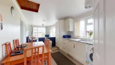 a kitchen with a table and a dining room at D58 Penlee, Riviere Towans in Hayle