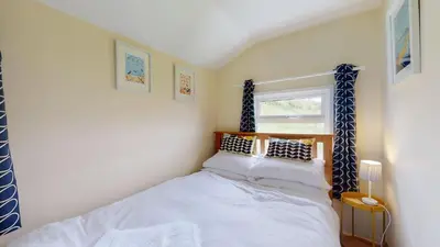 a small bedroom with a bed and a window at E08 Boness E8, Riviere Towans in Hayle