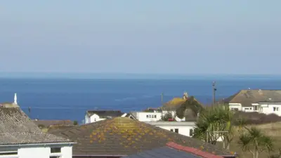 a group of houses with the ocean in the background at E08 Boness E8, Riviere Towans in Hayle