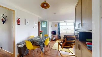 a kitchen and dining room with a table and chairs at E08 Boness E8, Riviere Towans in Hayle