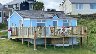 a blue house with chairs on a deck at E08 Boness E8, Riviere Towans in Hayle