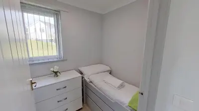 a small bedroom with a bed and a window at E14 Sea Haven, Riviere Towans in Hayle