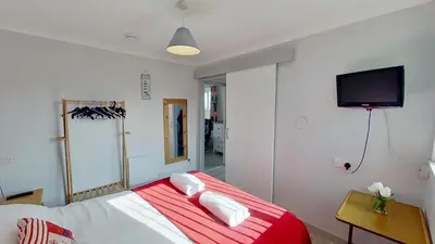 a bedroom with a bed and a tv on the wall at E14 Sea Haven, Riviere Towans in Hayle