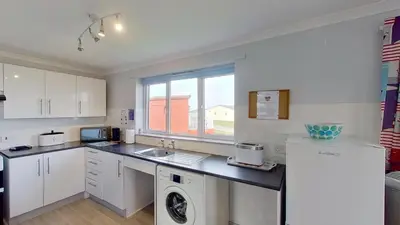 a kitchen with a sink and a dishwasher at E14 Sea Haven, Riviere Towans in Hayle